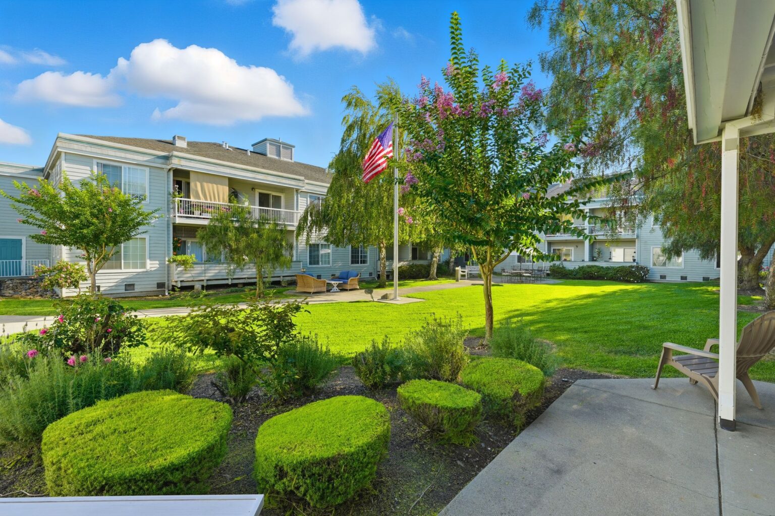 The main entrance 575 Vallejo Senior Apartments with an American flag on a green lawn.